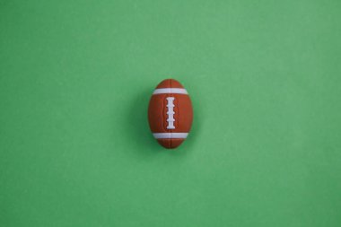 Yeşil arka planda ragbi topu minyatürü. Futbol gelişimi konsepti, eğitim fiyatları, çocuğun fiziksel gelişimi