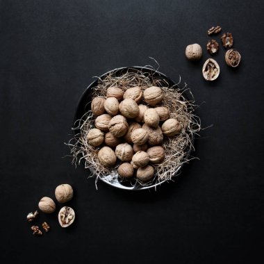 Siyah tabakta cevizler, siyah arkaplan. 