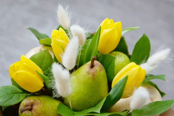 Bouquet of fruits and flowers. Pears and yellow tulips.