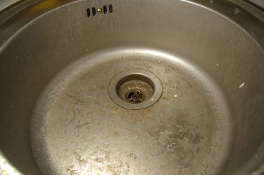 Kirli, paslanmaz çelik mutfak lavabosu. Baştan savma, bakımsız. Zavallı ev idaresi.