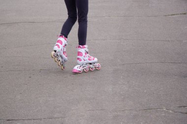 Kızın bacakları asfaltta beyaz ve pembe bigudilerle, ki bu da çatlamış. Kötü bir yolda gidiyoruz..