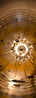 Plastik su şişesinin içinde damla izleri var. Arka plan aydınlatma dokusu