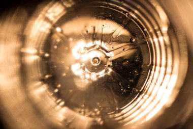 Plastik su şişesinin içinde damla izleri var. Arka plan aydınlatma dokusu