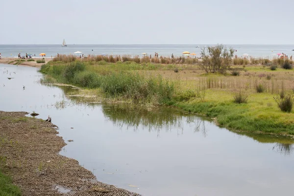 Mouth of a river in the sea. Vilanova i la Geltru beach, Garraf, Barcelona, Catalonia, Spain.