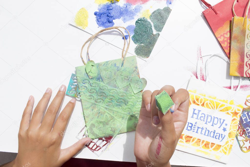 Stamping bag with stencils and sponge impregnated in paint. Making gifts to celebrate the birthday.