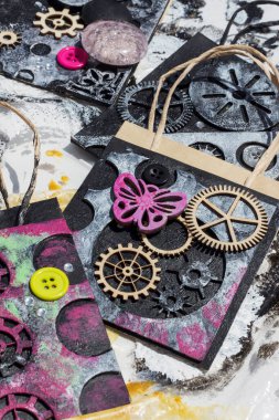 Çanta üst üste binen elementlerle süslenmiş ve steampunk stiliyle boyanmış. Kolaj kağıdı. Geri dönüştürülmüş malzeme ile el işi.