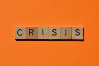 Kriz, 3 boyutlu tahta alfabe harfleriyle kelime turuncu arka planda izole edilmiş ve kopyalama alanı var