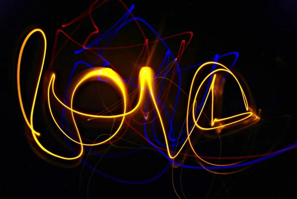 Light painting in yellow, blue and red of the word Love