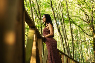 Bir sekoya ormanında podyumda genç ve güzel bir kız