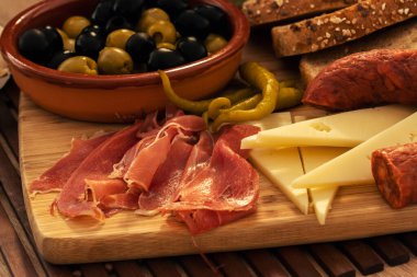 Karanlık bir sahnede tipik İspanyol yemekleri olan ahşap masa.