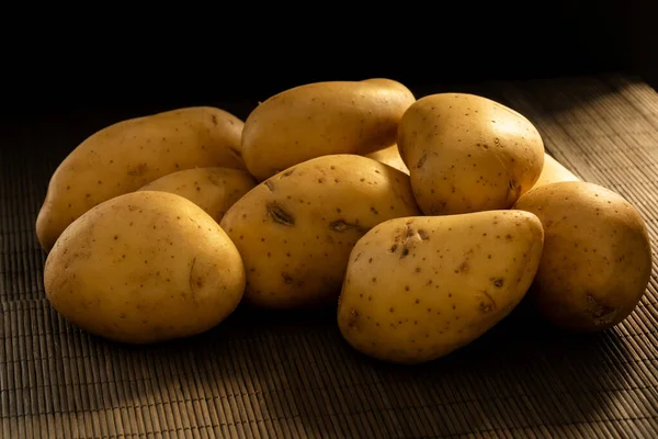 Ein Bündel Kartoffeln Auf Einer Hölzernen Tischdecke Einer Dunklen Szene — Stockfoto