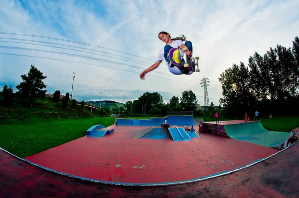 Skater Latający Wysoko Czerwono Niebieskim Skateparku Ładnym Zachmurzonym Niebem — Zdjęcie stockowe