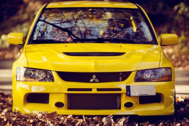 Santander, Cantabria / Spain, 11-18-2018: Mitsubishi Lancer Evolution 9, shot in a mountain road full of autumn leaves clipart
