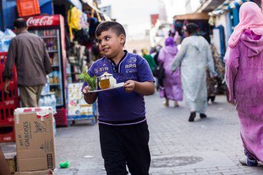 Essaouira - Fas; 09-28-2013: Genç çocuk marketteki ihtiyarlara çay götürüyor