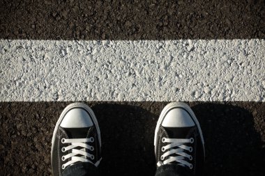 Asfaltta siyah spor ayakkabılar, üst manzara.
