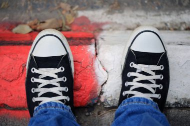 Kaldırımda siyah branda ayakkabılar.