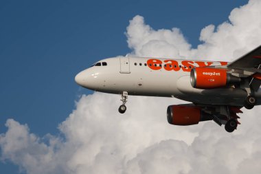Korfu, Yunanistan - 29 Mayıs 2009: Yolcu uçağı Easy Jet gökyüzünde, bulutlu mavi gökyüzü, yan görüş, iniş, kalkış, yatay yönelim