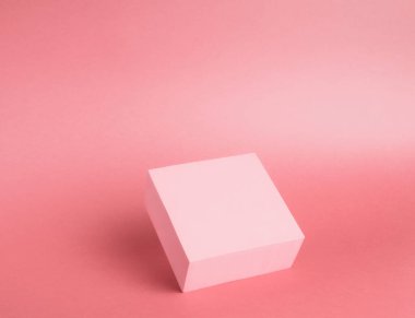 Kağıt zemin üzerinde parlak bir kürsünün (kaide) fotoğrafı. Pembe, değişken ve gölgeli. Reklam yeri. Boş ürün standı ve soyut arkaplan.