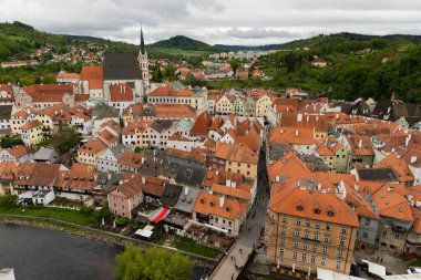 Kilisenin ünlü Cesky Krumlov Şatosu 'nun bulunduğu tarihi Cesky Krumlov şehrinin yukarıdaki panoramik manzara manzarası, ilkbaharda güzel bir gökyüzü ve bulutlarla yakalanan UNESCO Dünya Mirası Alanında yer alıyor.