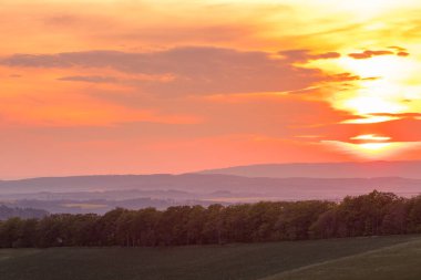 Beskydy bölgesinin ormanlık arazisinin üzerinde batan güneş ufkun ötesinde batıyor..