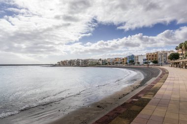 Büyük Kanarya 'da, okyanusa ve çevreye bakan güneşli bir günde bir sürü ağaç ve çevreleyen evleri olan şehir ve liman bölgesi.