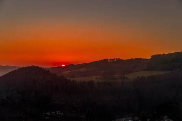 Close up sunset timelapse when sun is behind hills and mountains full of trees and moving clouds behind which sun sets a strong yellow-orange color view of the surrounding nature Beskydy Mountains