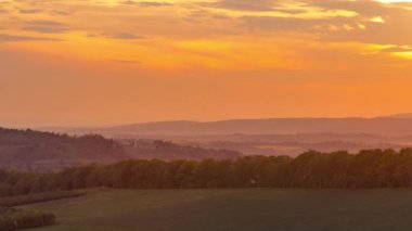 Gün batımında hareket eden bulutlarla Beskydy Çek Cumhuriyeti ulusal parkı üzerindeki ormanların ve tepelerin üzerindeki turuncu bulutların zamanı..