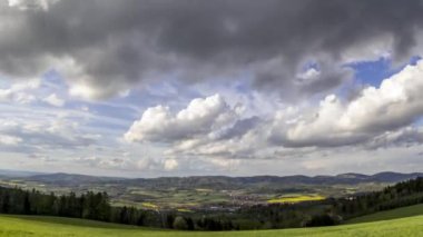 Geniş çekim süreleri çekim hızını aşan tarlalar bulutları yansıtıyor. Tepelerin aşağısındaki köyü gören bulutlar vadideki tarlaların ve evlerin bulunduğu Beskydy Zasova köyünün bulunduğu vadide uzanıyor.