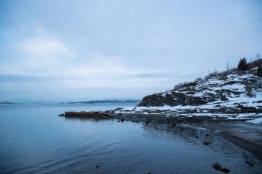 Oslo Norveç çevresindeki adaların kıyılarına bakan kışın deniz ve fiyort manzaralı.