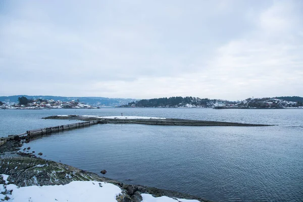 冬の間 ノルウェーのオスロ島とフィヨルドを見下ろす間を旅する船の桟橋 — ストック写真