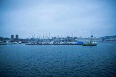 Oslo Norveç kıyıları kışın kentin merkezinde karla kaplı çok sayıda limanlı teknesiyle