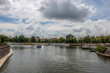 Şehirdeki Wroclaw nehrinin sol tarafında büyük bulut örtüsü ve köri var.