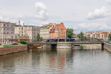 Şehirdeki Wroclaw nehrinin sol tarafında büyük bulut örtüsü ve köri var.