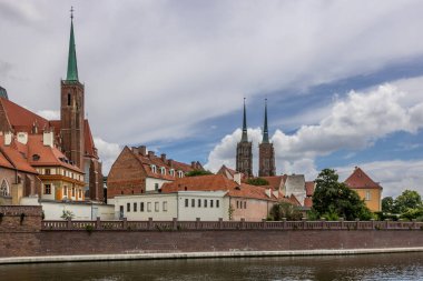Şehirdeki Wroclaw nehrinin sol tarafında büyük bulut örtüsü ve köri var.