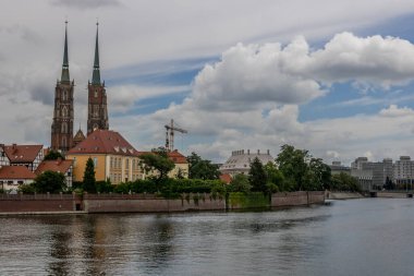 Şehirdeki Wroclaw nehrinin sol tarafında büyük bulut örtüsü ve köri var.