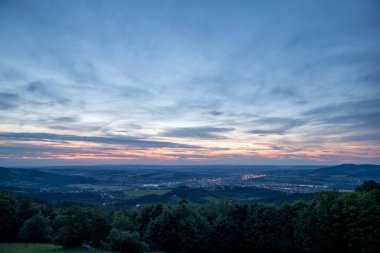 Şehir ve çevresindeki Valasske Mezirici kasabasının üzerindeki batan günbatımı kamuoyu yavaş yavaş çok renkli kara bulutları ve ufukta gizlenen güneşi aydınlatıyor..