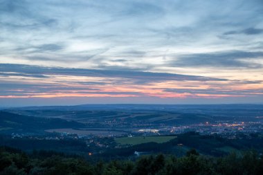 Şehir ve çevresindeki Valasske Mezirici kasabasının üzerindeki batan günbatımı kamuoyu yavaş yavaş çok renkli kara bulutları ve ufukta gizlenen güneşi aydınlatıyor..