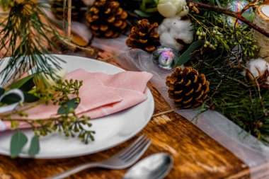 Çiçeklerle dolu eski ahşap bir düğün masası ve yiyecek için hazırlanmış bir yer. Kışın, ormanın ortasında, karla kaplı bir düğün merasimi.