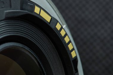 Kamerayla iletişimi sağlayan kişilerin karanlık arkaplan görüntüsünde merceğin DSLR kamerasına yakın plan fotoğrafı.