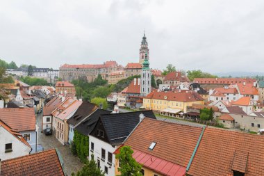 Kilisenin ünlü Cesky Krumlov Kalesi ile tarihi Cesky Krumlov şehrinin panoramik manzara manzarası, ilkbaharda güzel gökyüzü ve bulutlarla yakalanan UNESCO Dünya Mirası bölgesinde yer alıyor.