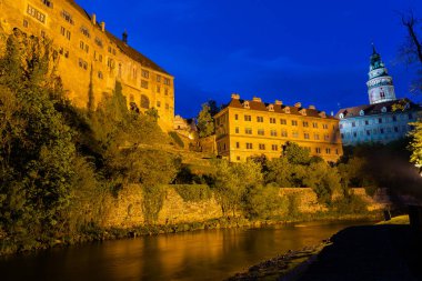 Günbatımında ünlü Cesky Krumlov Şatosu ile birlikte tarihi Cesky Krumlov şehrinin panoramik manzara manzarası, güzel gökyüzü ve bulutlarla kaplanmış UNESCO Dünya Mirası Bölgesi üzerindedir.