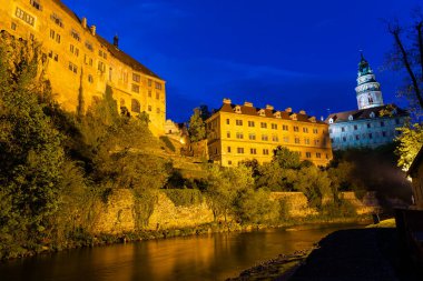 Günbatımında ünlü Cesky Krumlov Şatosu ile birlikte tarihi Cesky Krumlov şehrinin panoramik manzara manzarası, güzel gökyüzü ve bulutlarla kaplanmış UNESCO Dünya Mirası Bölgesi üzerindedir.