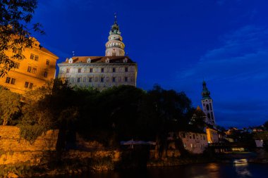 Günbatımında ünlü Cesky Krumlov Şatosu ile birlikte tarihi Cesky Krumlov şehrinin panoramik manzara manzarası, güzel gökyüzü ve bulutlarla kaplanmış UNESCO Dünya Mirası Bölgesi üzerindedir.