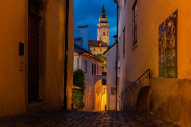 Gün batımında, Cesky Krumlov 'un dar sokağındaki sokak ışıklarıyla ünlü Cesky Krumlov Kalesi, UNESCO Dünya Mirası Bölgesi.