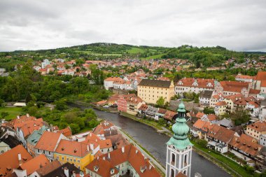 Kilisenin ünlü Cesky Krumlov Şatosu 'nun bulunduğu tarihi Cesky Krumlov şehrinin yukarıdaki panoramik manzara manzarası, ilkbaharda güzel bir gökyüzü ve bulutlarla yakalanan UNESCO Dünya Mirası Alanında yer alıyor.