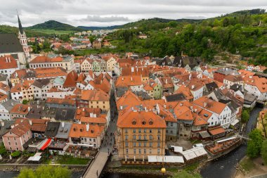 Kilisenin ünlü Cesky Krumlov Şatosu 'nun bulunduğu tarihi Cesky Krumlov şehrinin yukarıdaki panoramik manzara manzarası, ilkbaharda güzel bir gökyüzü ve bulutlarla yakalanan UNESCO Dünya Mirası Alanında yer alıyor.