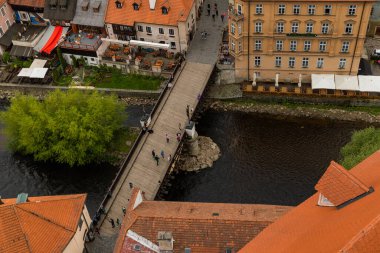 Kilisenin ünlü Cesky Krumlov Şatosu 'nun bulunduğu tarihi Cesky Krumlov şehrinin yukarıdaki panoramik manzara manzarası, ilkbaharda güzel bir gökyüzü ve bulutlarla yakalanan UNESCO Dünya Mirası Alanında yer alıyor.