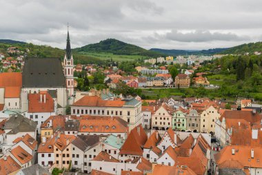 Kilisenin ünlü Cesky Krumlov Şatosu 'nun bulunduğu tarihi Cesky Krumlov şehrinin yukarıdaki panoramik manzara manzarası, ilkbaharda güzel bir gökyüzü ve bulutlarla yakalanan UNESCO Dünya Mirası Alanında yer alıyor.
