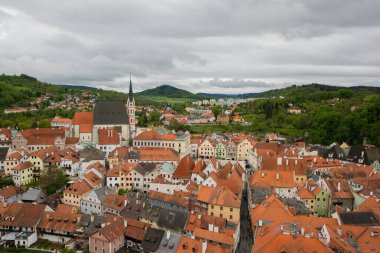 Kilisenin ünlü Cesky Krumlov Şatosu 'nun bulunduğu tarihi Cesky Krumlov şehrinin yukarıdaki panoramik manzara manzarası, ilkbaharda güzel bir gökyüzü ve bulutlarla yakalanan UNESCO Dünya Mirası Alanında yer alıyor.