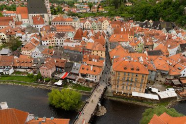 Kilisenin ünlü Cesky Krumlov Şatosu 'nun bulunduğu tarihi Cesky Krumlov şehrinin yukarıdaki panoramik manzara manzarası, ilkbaharda güzel bir gökyüzü ve bulutlarla yakalanan UNESCO Dünya Mirası Alanında yer alıyor.